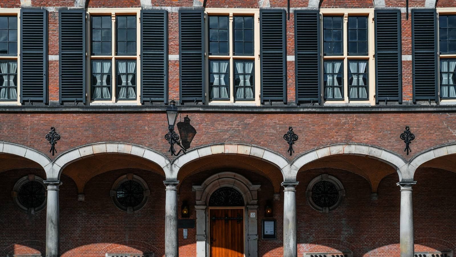 Bakstenen arcade met luiken en een houten deur in Den Haag