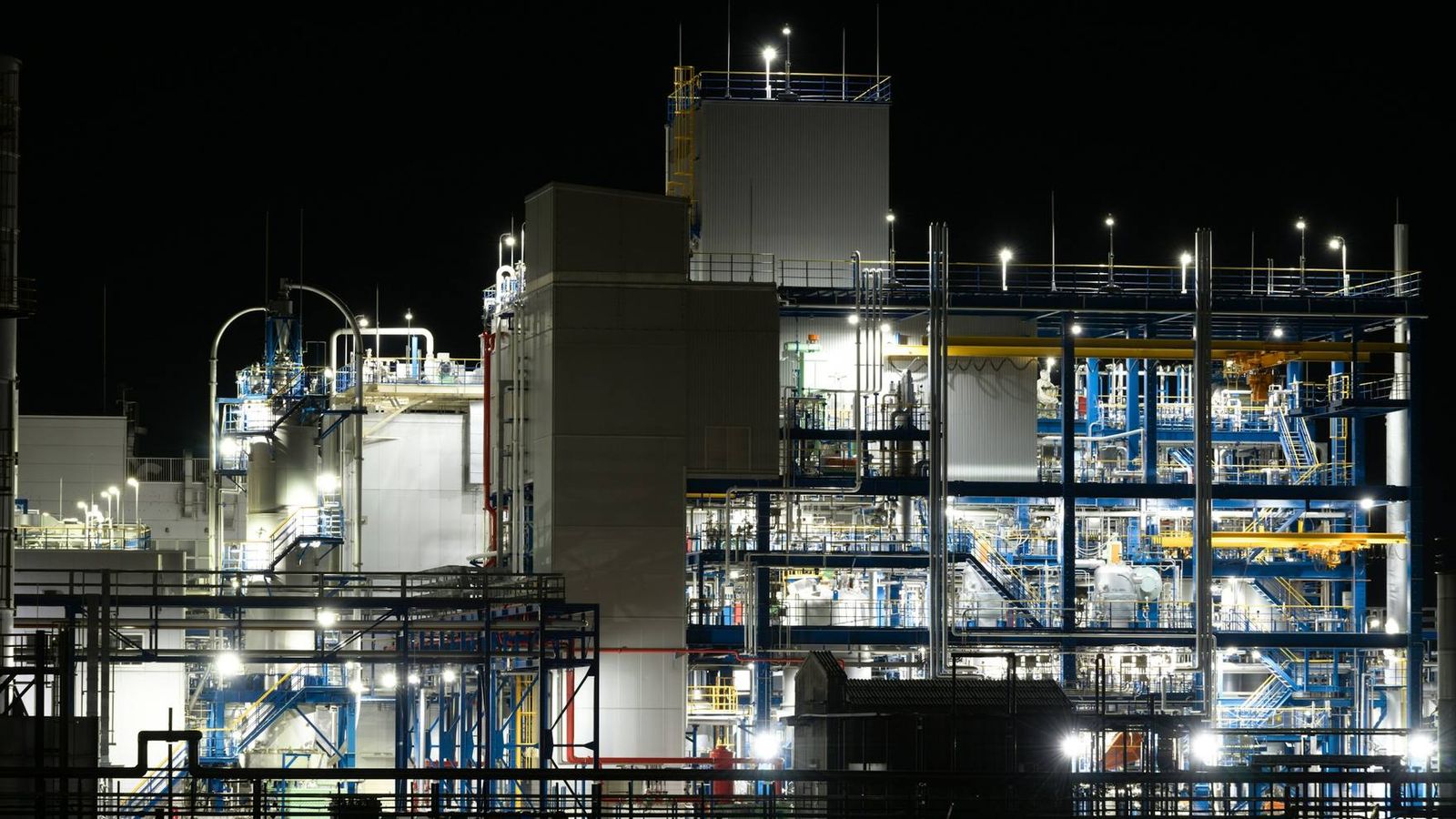 Industrieel complex bij nacht onder koel blauw licht