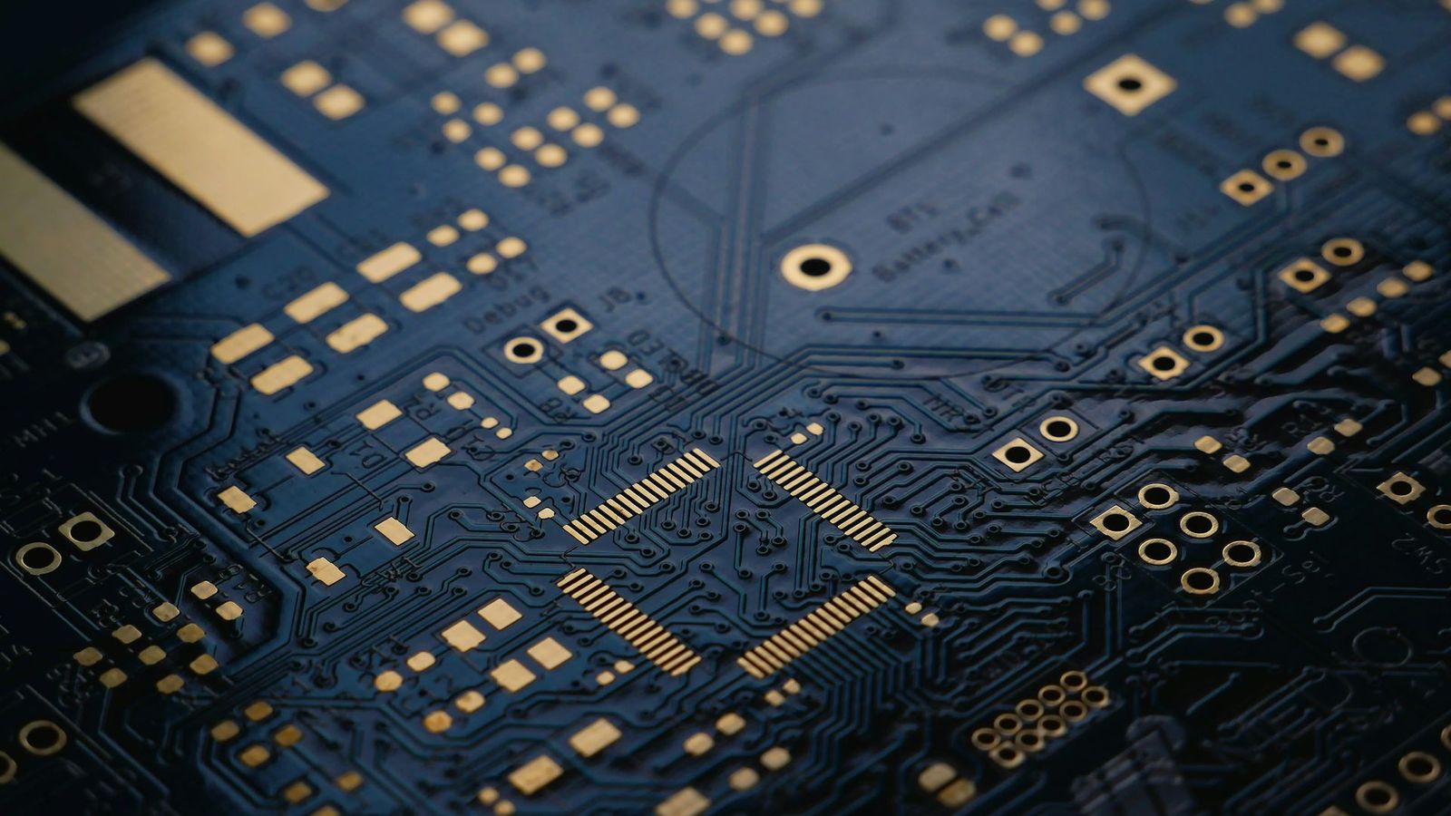 Close-up van een donkere printplaat met gouden contactvlakken